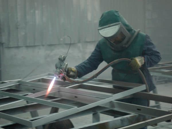 Ouvrier Galvamed réalisant une métallisation par projection thermique